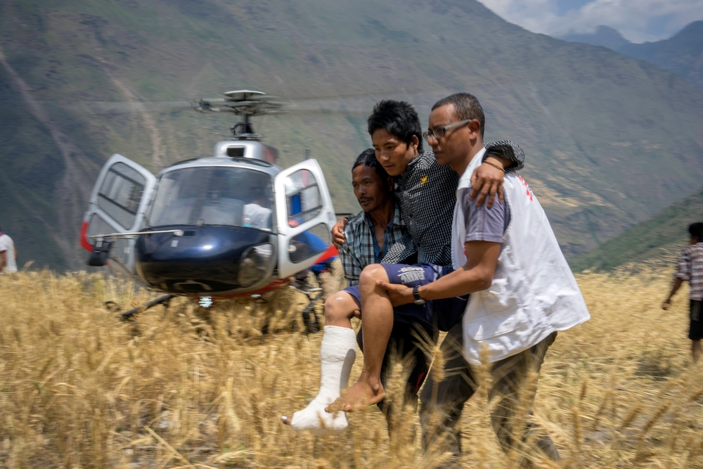 지진으로 왼쪽 다리를 다쳐 국경없는의사회의 치료를 받은 환자가 치료를 마치고 헬리콥터로 이송되고 있다.  ©Brian Sokol/Panos